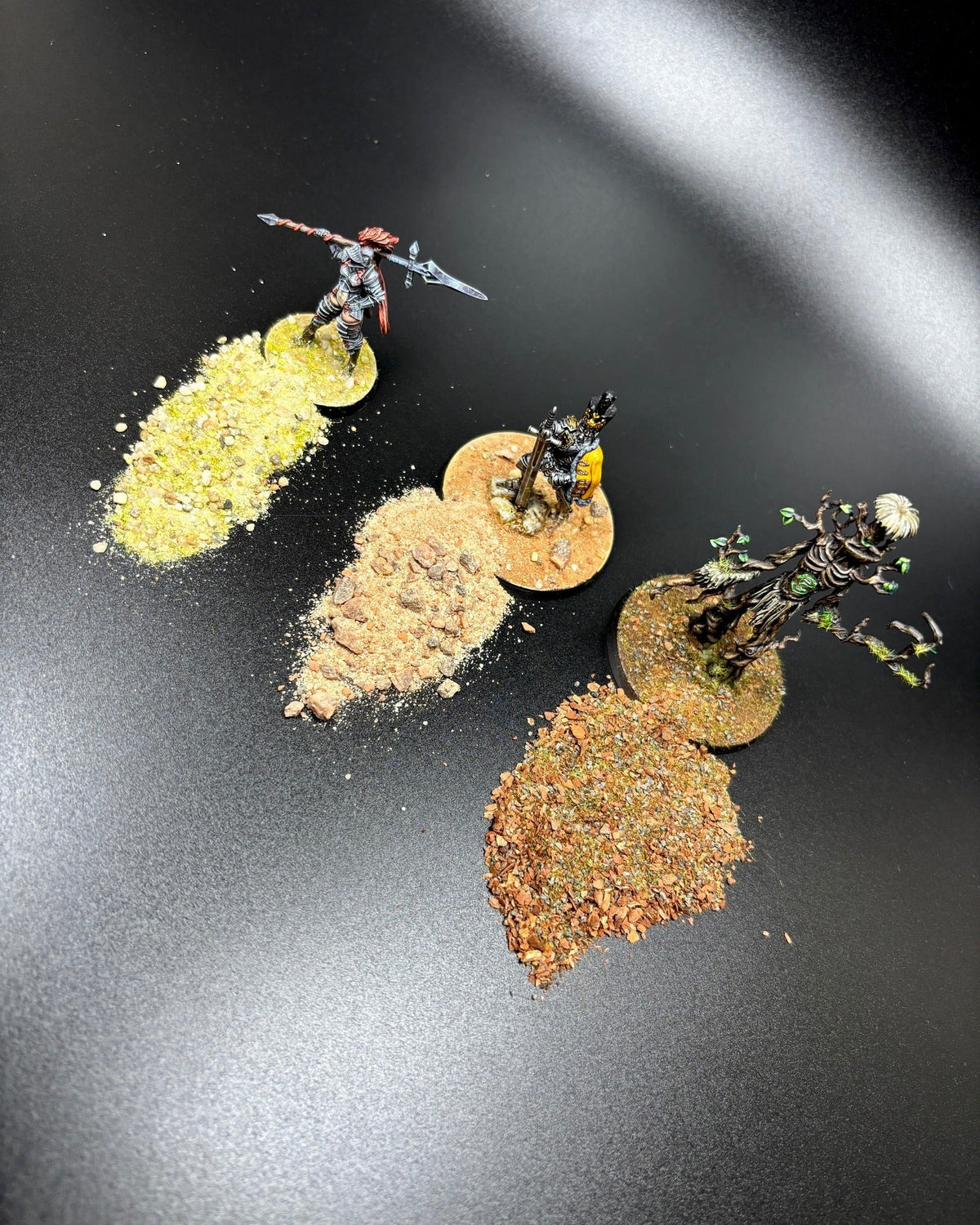 Vier gestaltete Miniaturen-Bases mit verschiedenen K&K Hobby Basing-Sorten